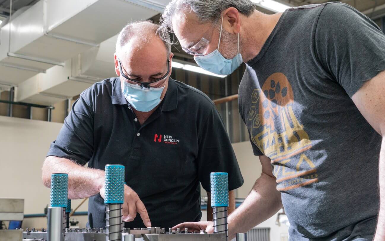 New Concept Technology employees soldering a circuit board